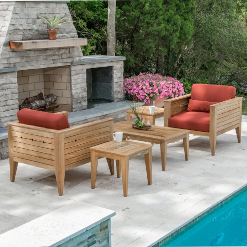 70507 Craftsman 5 piece teak Dining Set of 2 lounge chairs with cushions and 2 teak side tables and a teak coffee table on pool patio with pool on side and fireplace and shrubs in back