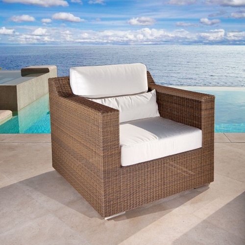 70508 malaga woven wicker armchair with canvas colored cushions next to pool on deck with ocean background
