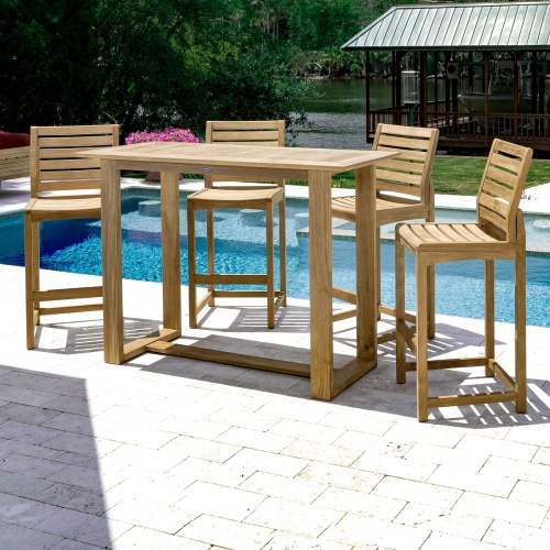 70512 Somerset 5 piece teak Barstool and Bar Set with 4 barstools in front of pool facing table with flowering plants screened porch by lake and trees in background
