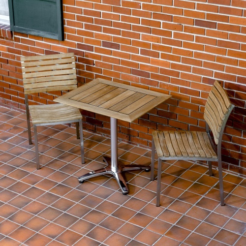 70665 Vogue Bistro Set of a  teak and stainless steel rectangular table and 2 teak and stainless steel side chair on tiled patio against brick wall