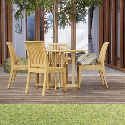 70732 Barbuda Laguna 5 pc Teak Dining Set on patio with trees and landscape rocks and french doors and windows of house in the background