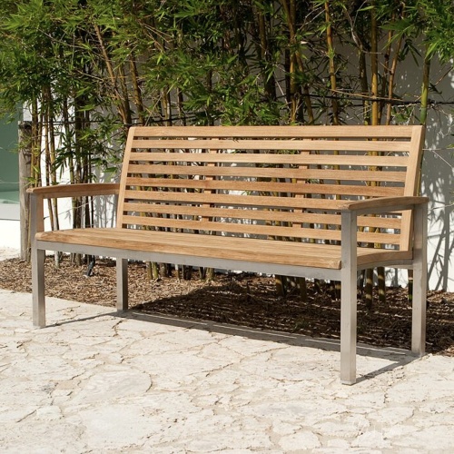70779 Vogue teak and stainless steel 5 foot long bench on a walkway with bamboo trees and building in back