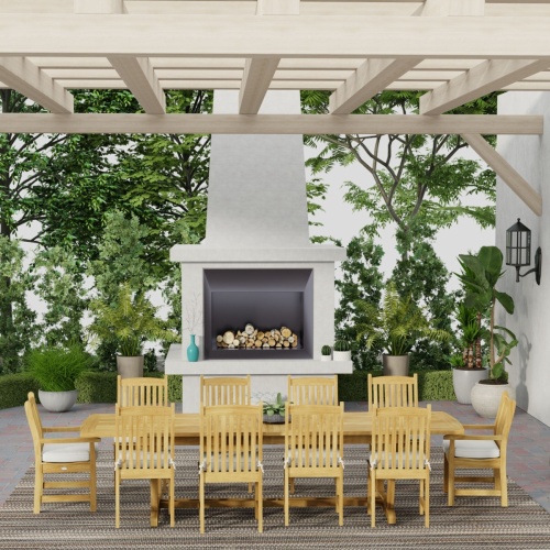 70791 Veranda 11 pc teak Dining Set of Grand Veranda Rectangular Dining Table and 8 Veranda Side Chairs and 2 Armchairs with optional cushions in front of a fireplace on an outdoor patio surrounded by plants