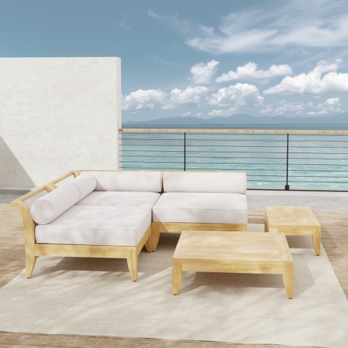 70822 Aman Dais 5 piece teak Daybed Set of 2 End Sectionals and 1 Corner Sectional and a teak coffee and side table on wood patio against a wall with railing and ocean in background