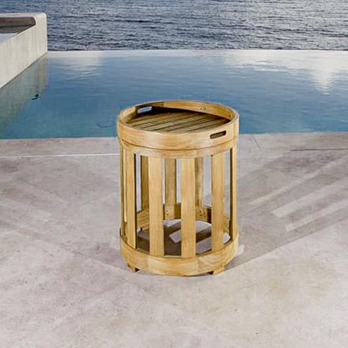 70872 Kafelonia teak side table with attached tray on concrete patio in front of infinity pool overlooking ocean
