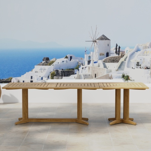 70936 Pyramid Teak Table Set of Pyramid Teak Rectangular Table and Square Table in side profile on outdoor terrace with houses and ocean in background