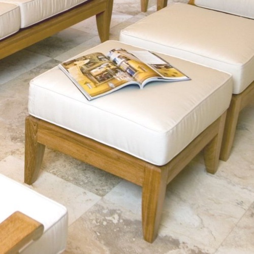 72324LM Laguna teak ottoman cushions with open magazine on top on limestone patio with other Laguna pieces