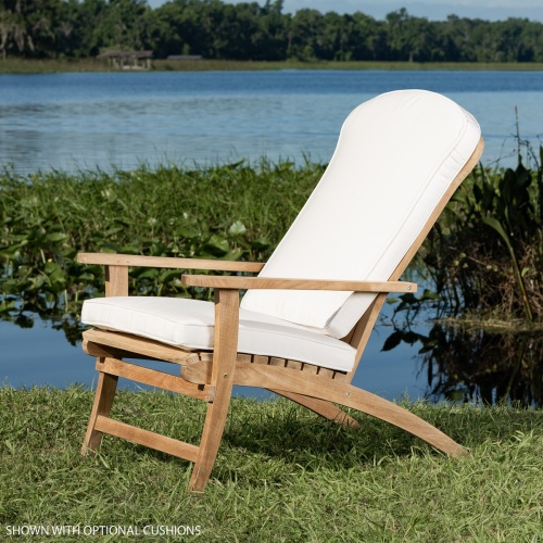 12221 Adirondack chair with back and seat cushions on green grass side view with lake with water lilies and plants in background