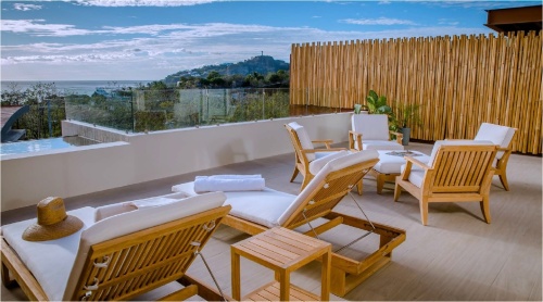image of two 16770DP Horizon Loungers on patio with bamboo fence and ocean in background