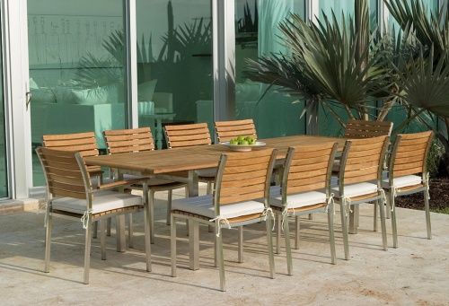 25025RF Vogue teak and stainless steel Extension Rectangular Table refurbished with 10 side chairs with optional seat cushions a bowl of apples on outdoor patio with plants in background