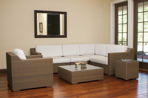 31001dp Malaga synthetic wicker collection on wood floors wall mirror above sofa floating candle and bowl of snacks on table with windows overlooking yard    