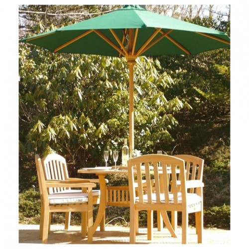 70003 Curved Back teak 5 piece Dining Set with optional seat cushions and optional opened market umbrella side view on  teak tiled patio with shrubs and trees in background