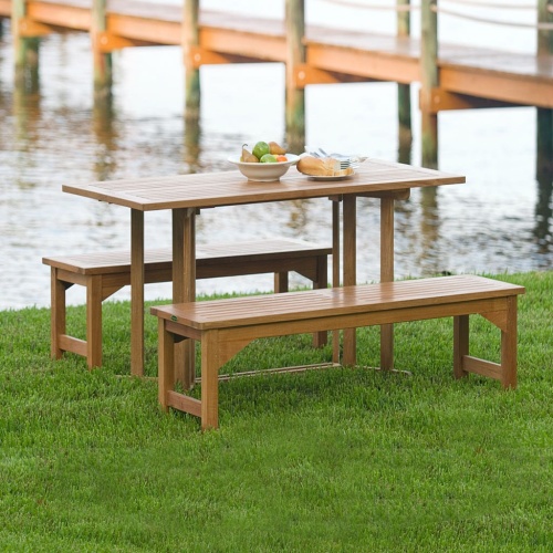 70061 Barbuda Picnic Table teak Dining Set white bowl of whole fruit and plate of french bread on table on grass field with lake and dock in background
