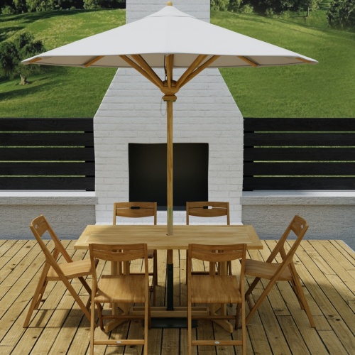 70472 Surf Nevis Teak 7 pc Dining Set with optional umbrella in  side view on wood deck in front of an outdoor fireplace and fence and hillside in background