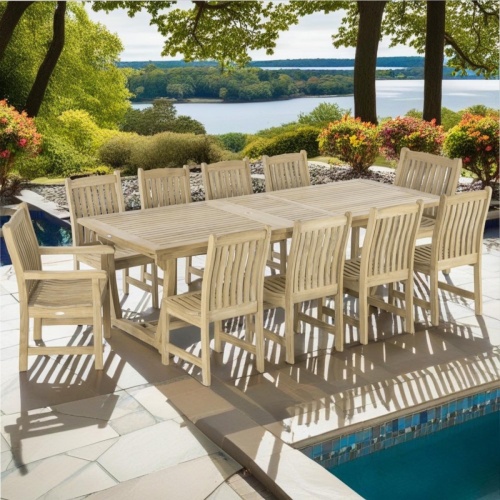 70791 Veranda 11 pc teak Dining  Set of  Grand Veranda Rectangular Extension Dining Table and 8 Veranda Side Chairs and 2 Armchairs on pool deck surrounded by plants and trees with water inlet in background