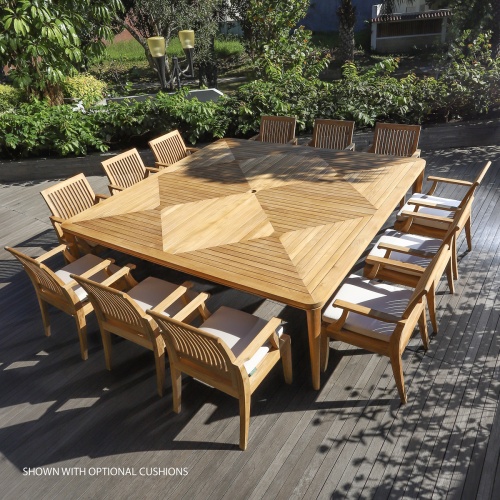 70801 Pyramid Laguna Teak Square 13 piece Dining Set with optional seat cushions on a wood deck outdoors aerial angled view with landscaped shrubs and house in background