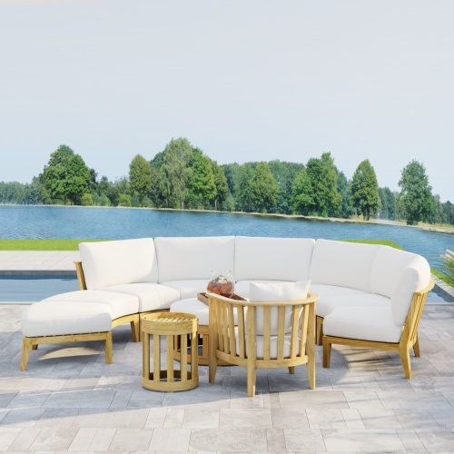70864 Kafelonia 7 pc Lounge Sofa Set in angled front view with tray of Sangria and 2 glasses on Ottoman on tiled patio to pool with a lake and trees in background