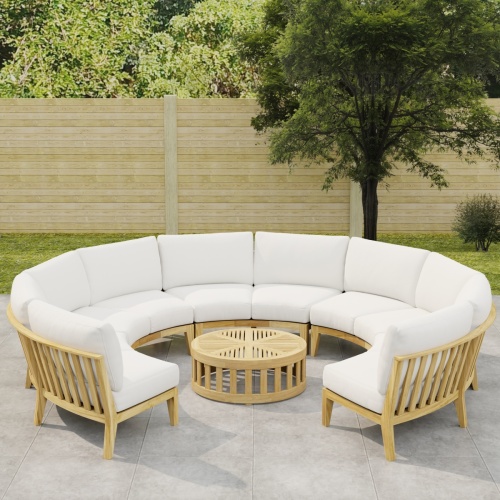 70870 Kafelonia Lounge Sofa 6 pc Set showing partial view of  Kafelonia Sofa Sectional Bench and a Teak Coffee Table angled on tiled patio with wood fence and trees in background