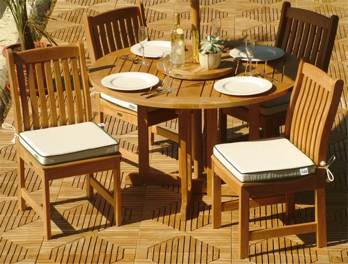 11315RF Veranda teak dining side chair with seat cushions with teak round table with optional Lazy Susan showing 4 plates and wine bottle and 4 wine glasses on teak floor