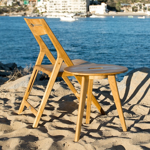 folding Surf Side Chair beside surf side table on sand overlooking lake by boat dock