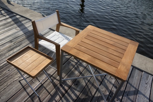 25815 Odyssey Teak and Stainless Steel 32 Inch Square Outdoor Folding Table and Odyssey Dining Chair and Side Table and Teak Tray on top  aerial view on boat dock with lake in background