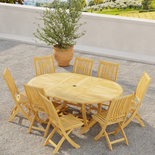 70060 Barbuda Martinique 9 pc Dining Set in angled aerial view on outdoor terrace next to potted tree with hillside view  with trees in background