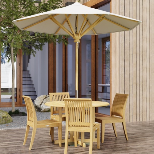 70732 Barbuda Laguna 5 pc Teak Dining Set in angled side view with optional opened umbrella on patio with trees and french doors and windows of house in the background