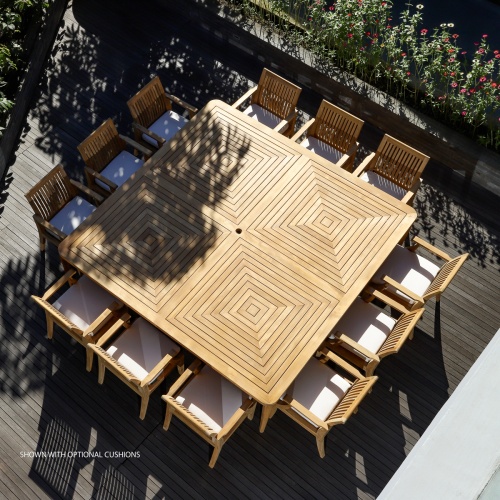 70801 Pyramid Laguna Teak Square 13 piece Dining Set with optional seat cushions on a wood deck outdoors aerial view with landscaped shrubs in back