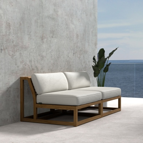 70821 Maya Armless Love Seat showing 2 Maya Slipper Chairs in angled side view on tile next to a potted plant with ocean and blue sky in the background
