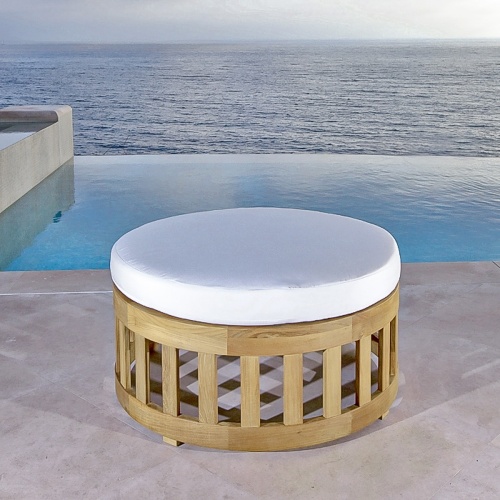 70859 Kafelonia 36 inch Ottoman with optional cushion on paver patio in front of a pool and ocean background