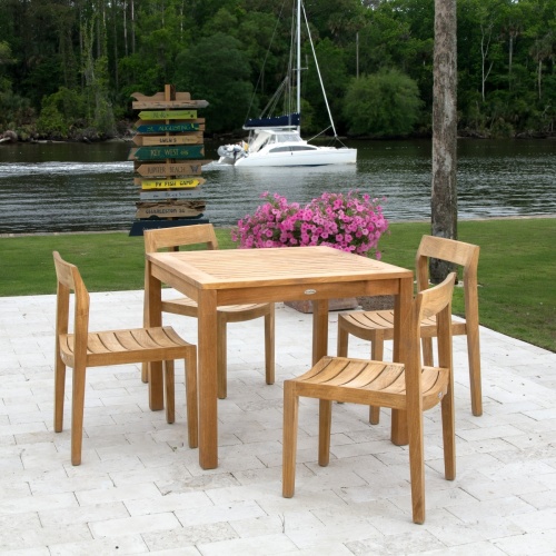 11901RF Horizon Side Chair refurbished shown with Horizon 5 piece Teak Dining Set on patio overlooking lake with a yacht going by