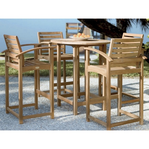 15334 Somerset teak 36 inch diameter Round Table and 4 backless barstools on stone patio a pitcher of ice water on table overlooking grass and trees in background