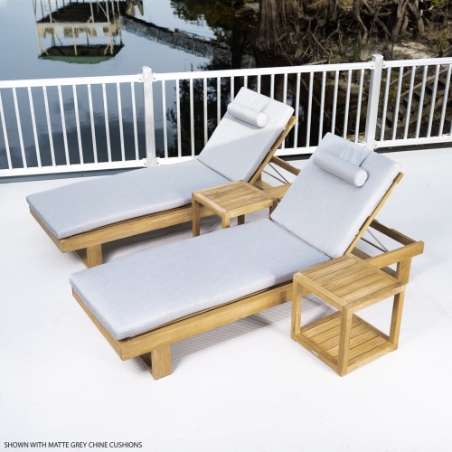 70308 Horizon teak double chaise set with cushions left side angled aerial view on concrete deck with metal railing trees boathouse and dock in background