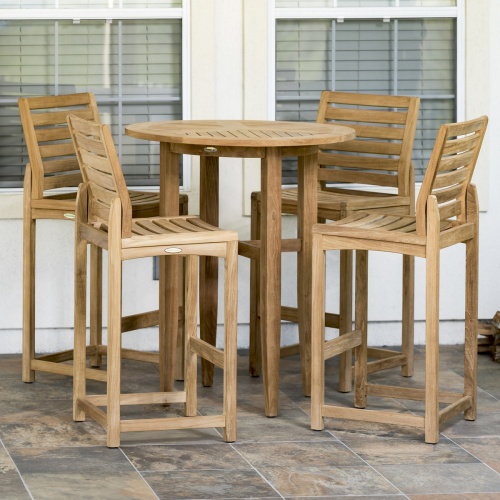 70532 Teak 5 piece Bar Table Set of 4 Somerset barstools and Laguna Table on tile patio against 2 windows of house in background
