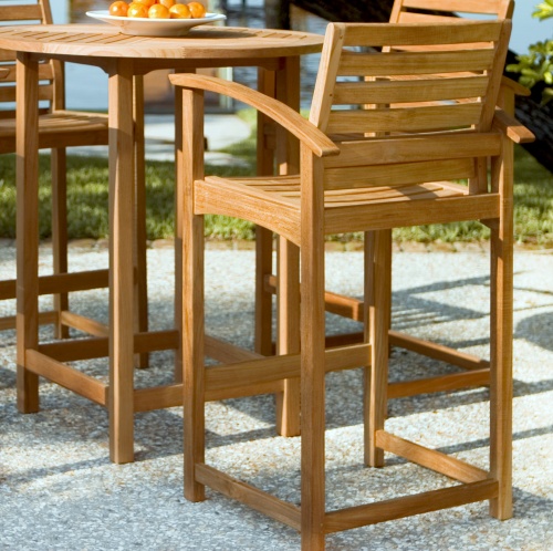 12466 Somerset Teak Bar Stool rear angled and table with bowl oranges on concrete patio overlooking lake in background