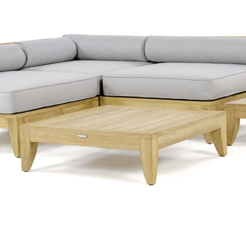 14315 aman dais teak coffee table angled shown with the aman dais sectional set on a white background