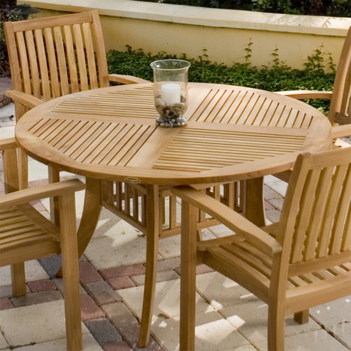 70027 Grand Hyatt Teak 5 piece Dining Set with candle holder in center on stone patio