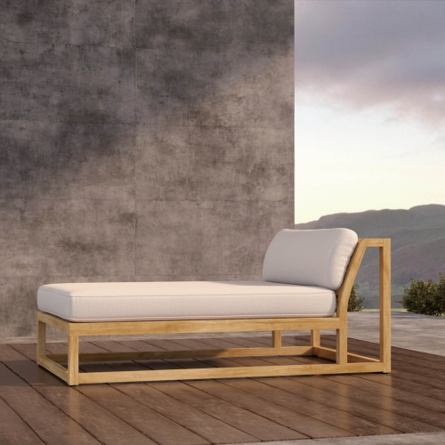16800DP Maya teak chaise daybed with canvas colored cushions in side view on wood deck in front of a wall with hillside views in the background 