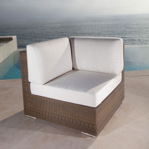 70242 malaga woven wicker cushioned corner sectional front view on outdoor patio with infinity pool and ocean backdrop