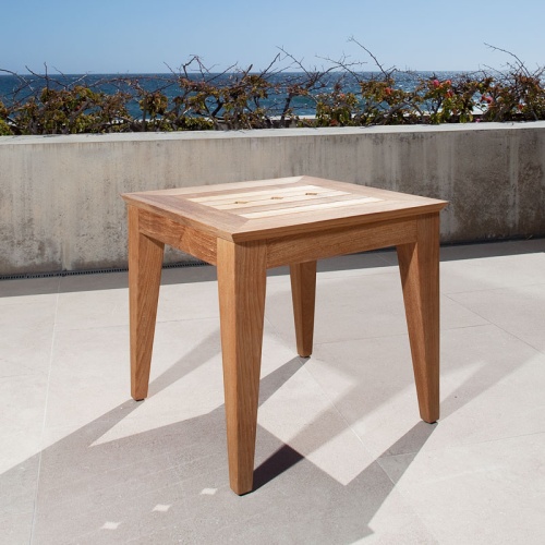 70507 Craftsman teak side table on terrace corner angled view with shrubs and ocean and blue sky background
