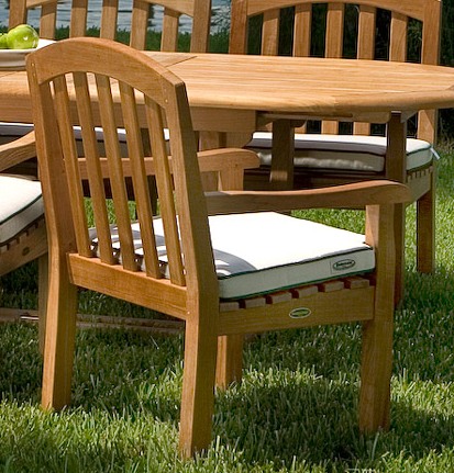 70003 Curved Back Dining Chair with optional seat cushion and teak 48 inch Round Dining Table closeup view on grass lawn