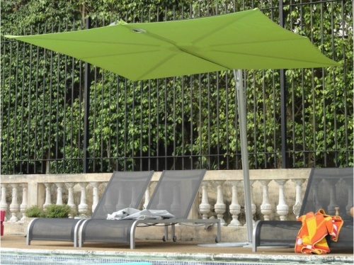sps25100ffb spectra solo umbrella only with three sling loungers with towels on two concrete railing black fence and landscaped trees in background