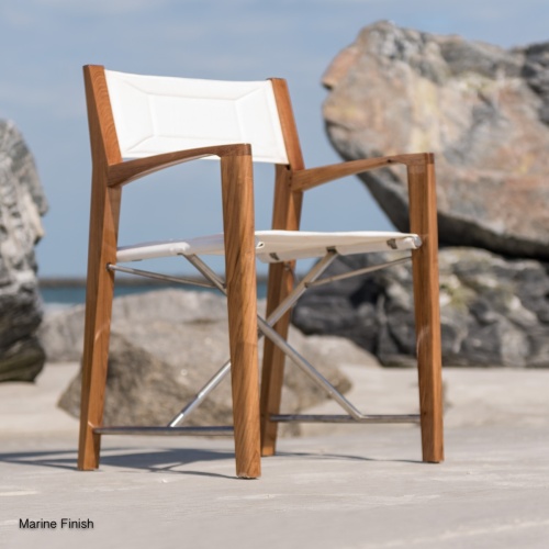 12915RF Refurbished Odyssey Director Chair in marine gloss finish right side angled front facing view on sandy beach by boulder with ocean and blue sky in background