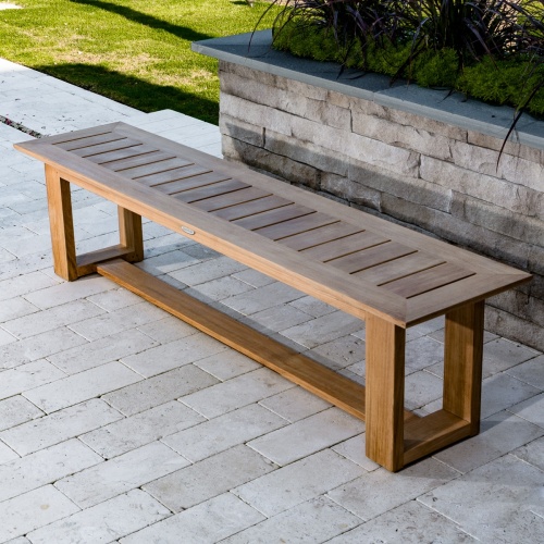 13909RF Refurbished Horizon teak 6 foot long Backless Bench angled aerial view on paver patio with landscape plants and green grass in background 