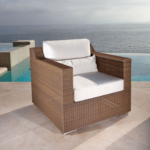 70242 malaga woven wicker armchair with cushions on outdoor patio with infinity pool and ocean backdrop