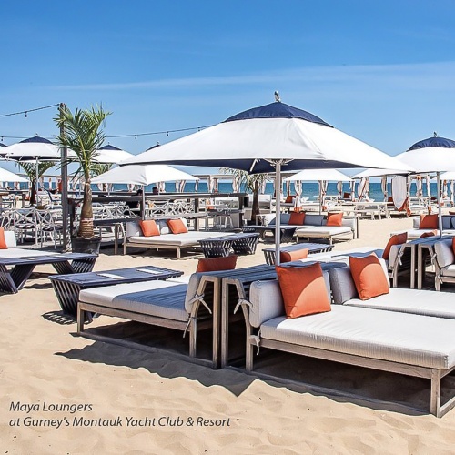 16800DP Maya teak chaise loungers with canvas colored cushions and throw pillows on the beach with ocean background at gurneys montauk yacht club resort