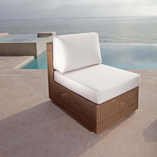 70242 malaga woven wicker slipper chair with cushions on outdoor patio with infinity pool and ocean background