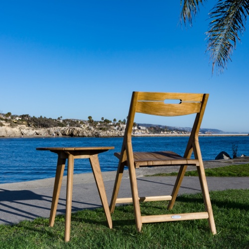 70677 surf teak folding chair and side table on sand with lake in background