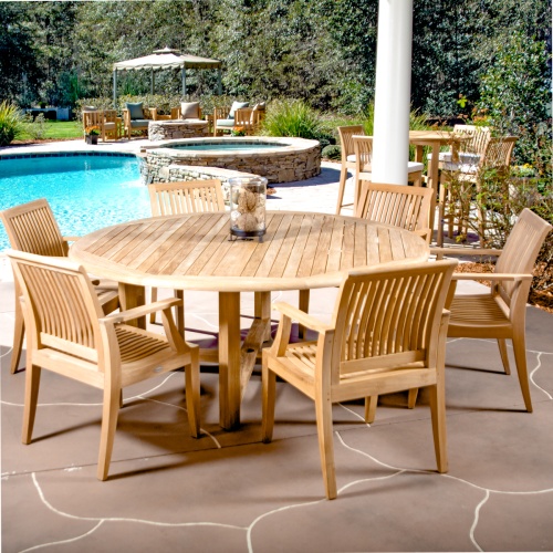 70418 Buckingham Laguna 7 piece round Dining Set with glass jar on table on stone patio with pool and hot tub and landscape plants in background