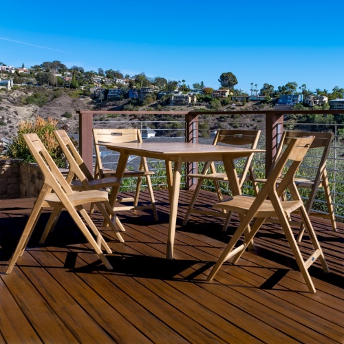 11916 Surf Round Teak Dining Set for 4 on wooden deck overlooking pine trees and ocean view